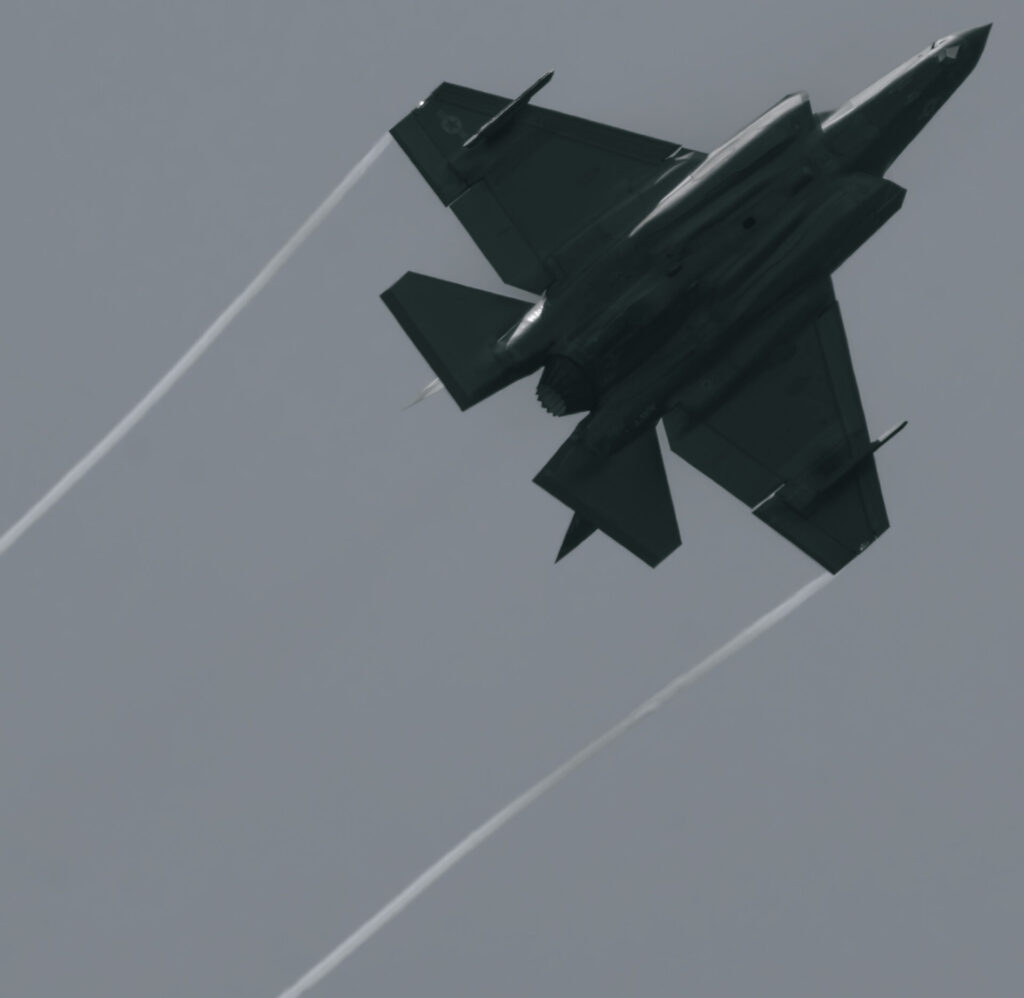 旋回をするF-35戦闘機。翼端からベイパーが伸びている。