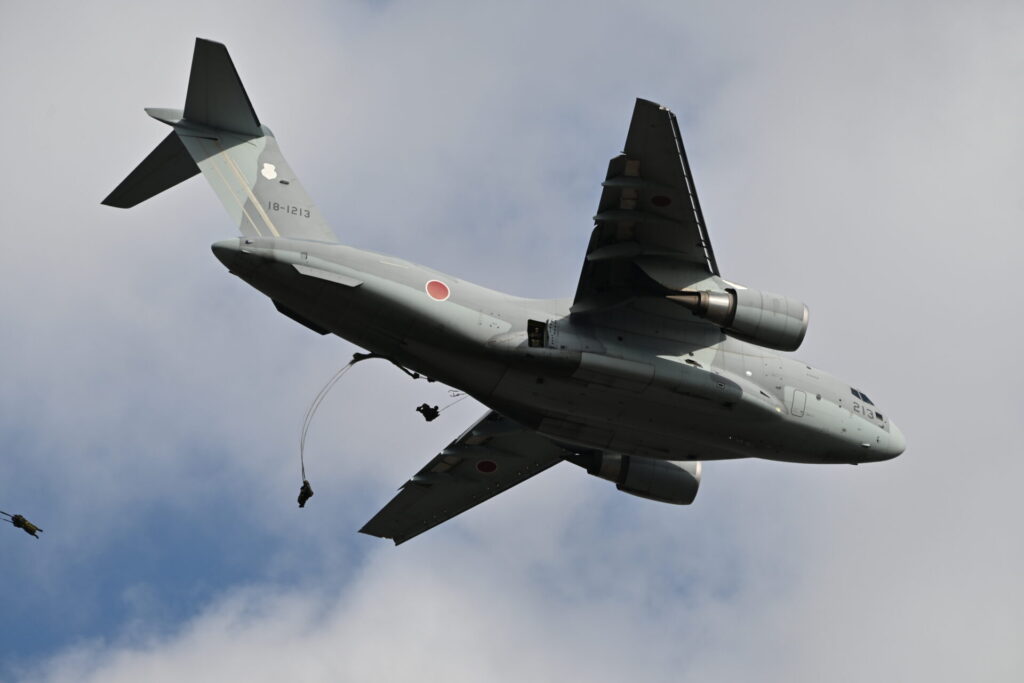 降下訓練始めでC-2輸送機からパラシュート降下を披露する空挺隊員。